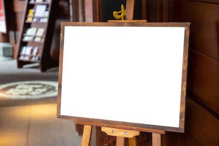Blank advertisement wooden board at the entrance to shop or restaurant. Marketing and business mockup with blank billboard.の写真素材