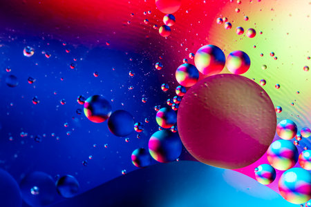 Macro shot of oil bubbles with water on colorful background. Space and universe planets styled...