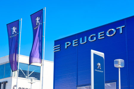Moscow, Russia - May, 2018: Peugeot automobile dealership building with flags against blue sky. PSA Peugeot Citroen group is one of the biggest car manufacturers in the world.のeditorial素材