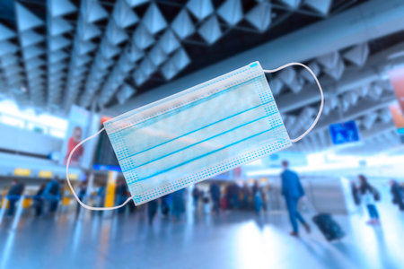 virus security restrictions in airports concept. Airport terminal with medical mask on the foregroundの写真素材