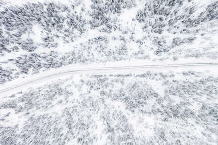 Aerial drone view of road in winter forest.の写真素材