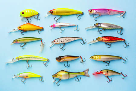 Fishing spinning colorful wobblers or lures on blue background. Fishing background.の写真素材