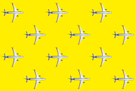 Travel and vacation concept. Top view of plane on bright yellow color background pattern. Mockup for travel projectの写真素材