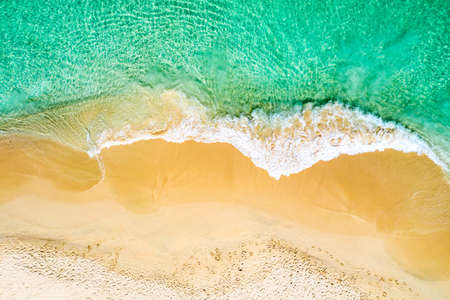 Top view aerial drone photo of ocean seashore with beautiful turquoise water and sea waves....