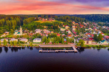 Aerial drone view of ancient russian town Ples on the Volga river with colorful sunset.