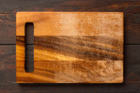 Used rectangular bamboo wooden cutting board on wooden table. Top view. Mock up for food projectの写真素材