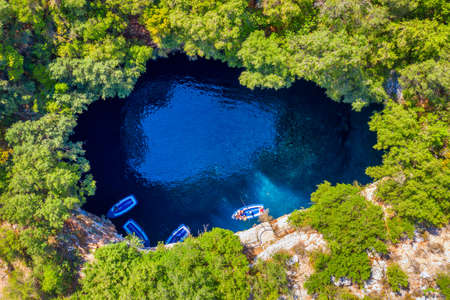 Famous tourist attraction. Aerial drone view of iconic cave with Melissani Lake near Sami village, Kefalonia island, Greece.の写真素材
