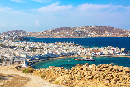 Mykonos town port with red churches, famous windmills, ships and yachts during summer sunny day. Aegean sea, Greece.のeditorial素材