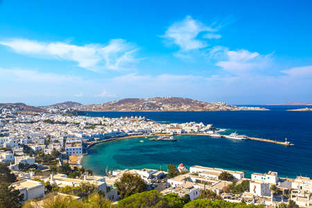 Chora port of Mykonos island with red church, famous windmills, ships and yachts during summer sunny day. Aegean sea, Greece.の写真素材