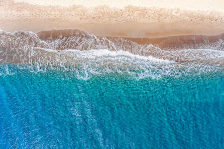Top view aerial drone photo of Perissa beach with beautiful turquoise water and sea waves. Vacation travel background. Aegean sea, Santorini Island, Greece.の写真素材