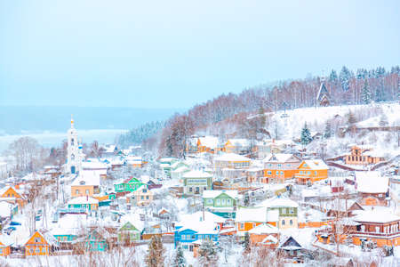 Ancient russian town Ples with old wooden colorful houses on the Volga river in winter with snow. Ivanovo region, Russia.の写真素材