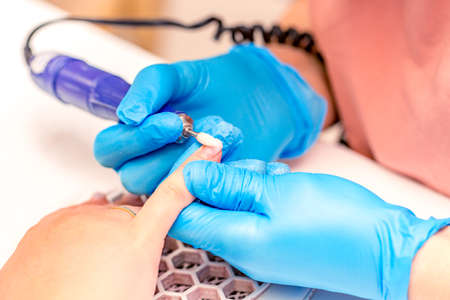manicure process. The manicure master polishes the nail using a machine. Close up manicure process.の写真素材