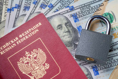 Russia Sanctions and Ukraine war concept. Russian Federation passport, padlock on american dollars. Currency ban in Russia.の写真素材