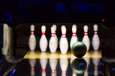 Bowling alley. Green bowling ball rolling into the pins.の写真素材
