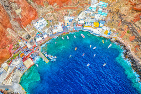 Aerial drone view of Old port Amoudi bay in Oia village with fishing boats. Santorini island in Aegean Sea, Greece.の写真素材
