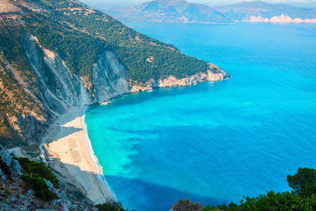 Top view aerial drone photo of Myrtos beach with beautiful turquoise water, sea waves and straw...