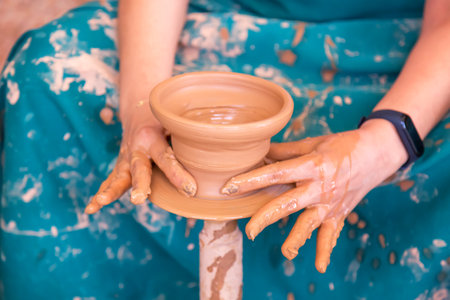 Female potter making ceramic pot on the pottery wheel.の写真素材