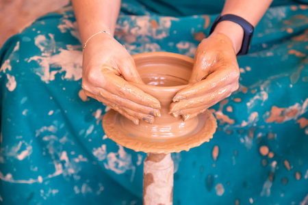 Female potter making ceramic pot on the pottery wheel.の写真素材