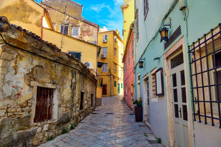 Kerkyra city narrow street view with colorful houses during sunny day. Corfu Island, Ionian Sea, Greeceの素材 [FY310189957203]