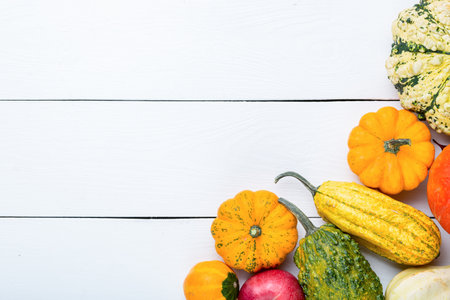 Autumn thanksgiving background with pumpkins on white wooden table. Top view with copy space for your text.の写真素材