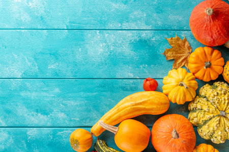 Autumn thanksgiving background with pumpkins and foliage on blue wooden table. Top view with copy space for your text.の写真素材