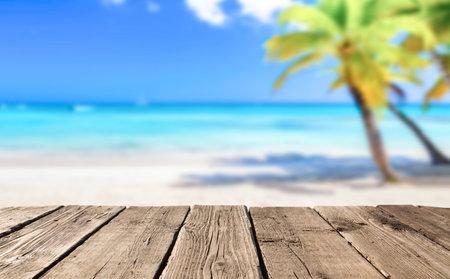Beach summer background with wooden pier or table and landscape of beach with palms and blue sky. free space.の写真素材