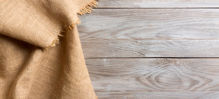 Burlap hessian sacking cloth on wooden table background with free spaceの写真素材