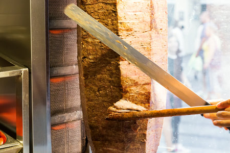 Cutting with knife doner traditional turkish Doner Kebab meat. Turkish cuisine street food in Istanbul, Turkeyの写真素材