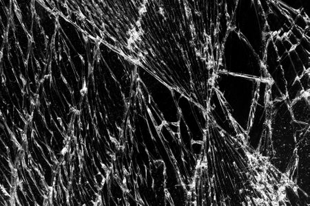 Broken black glass abstract background. Black cracked Touch Screen Phone display background. Texture for your projectの写真素材