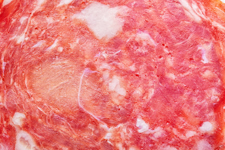 Sausage slice of salami close up background. Smoked semi-dry spanish sausage texture.の写真素材