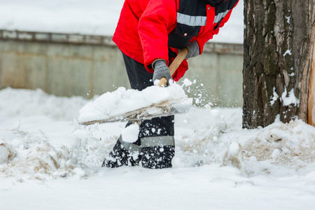Communal services worker removes snow from road in winter. Cleaning city streets and roads after snow storm in Moscow, Russia.の写真素材