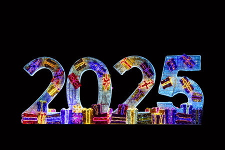 Illuminated 2025 numbers decorations with gift boxes or presents isolated on black background. New year and Christmas celebration.の写真素材