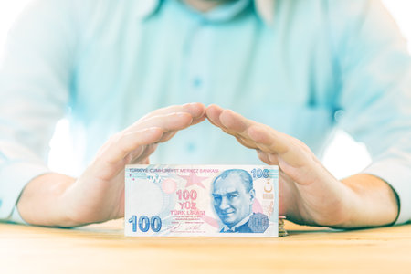 Saving money. Accounting, business, budget and finance concept. Male hands above one hundred Turkish Lira banknoteの写真素材