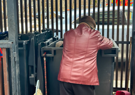Poor old homeless pensioner looking for food in trash cans in Moscow, Russia.の写真素材