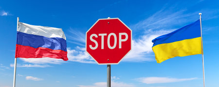 Stop Russian invasion concept. Red stop traffic regulatory warning sign between waving Russian and Ukraine flags against blue sky with clouds.の写真素材