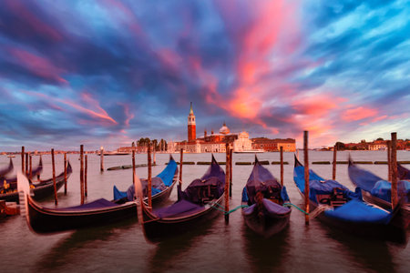 San Giorgio Maggiore church and gondolas in Venice, Italy during colorful pink sunset evening twilight. Famous landmark in Veniceの写真素材