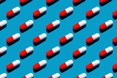 Pattern made with pharmaceutical medicine red white capsules on blue background. Medicine conceptの写真素材