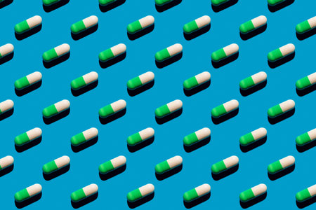 Pattern made with pharmaceutical medicine green white capsules on blue background. Medicine conceptの写真素材