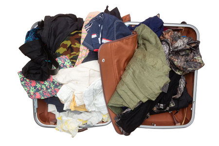 Open suitcase with belongings and clothes isolated on white background. Top view