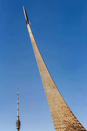 Conquerors of space monument near Vdnkh Metro station and Ostankino TV Tower in Moscow against blue sky.の写真素材