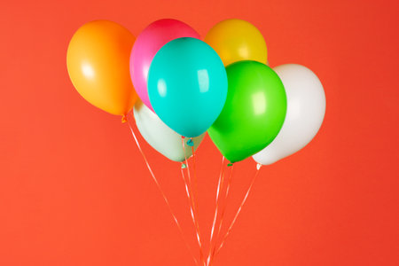 Children's party colorful balloons against orange background. Valentines day or birthday party conceptの写真素材