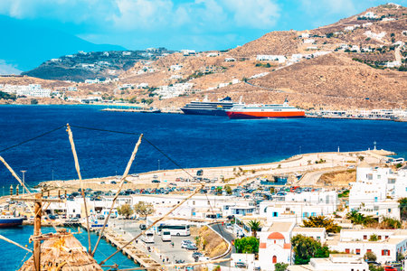 Famous old windmill in Chora with city view and cruise ships. Summer sunny day. Mykonos island, Greece.の写真素材