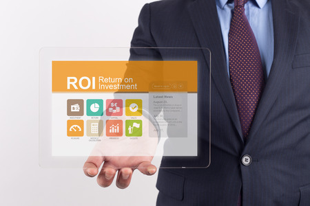 Hand Holding Transparent Tablet PC with ROI Return on Investment screenの写真素材