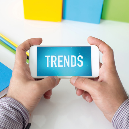 Man holding smartphone which displaying Trendsの写真素材