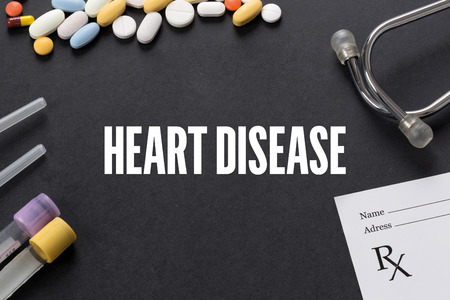 HEART DISEASE written on black background with medication