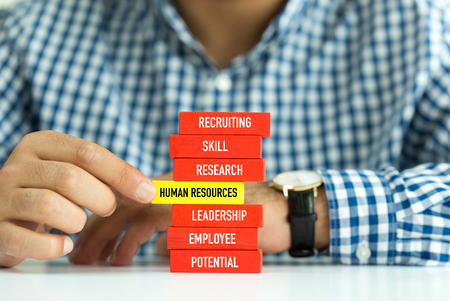 Businessman Building HUMAN RESOURCES concept with Wooden Blocksの写真素材