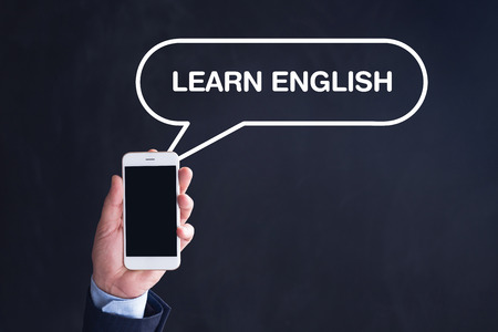 Hand Holding Smartphone with LEARN ENGLISH written speech bubbleの写真素材