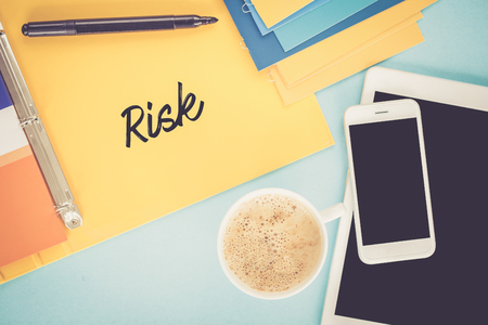Notepad on workplace table and written RISK conceptの写真素材