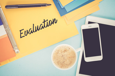 Notepad on workplace table and written EVALUATION conceptの写真素材