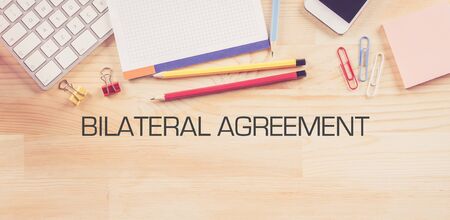 Business Workplace with  BILATERAL AGREEMENT Concept on Wooden Backgroundの写真素材